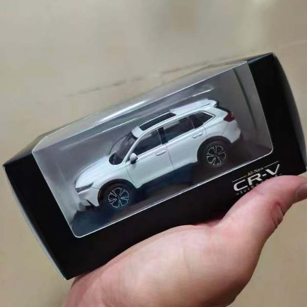 покупатель выбирает миниатюрную модель автомобиля в магазине