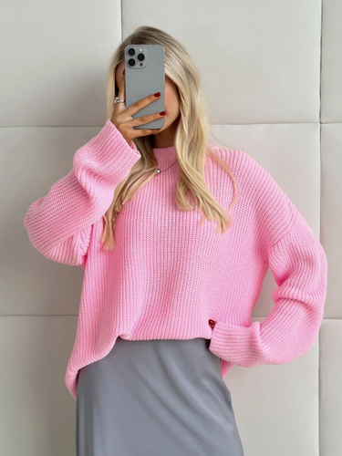 розовый вязаный свитер на вешалке