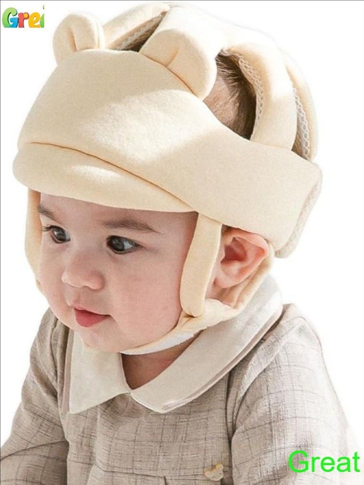 ребенок в защитном шлеме для ползания на ковре