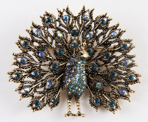 крупным планом серебряная брошь с павлином и голубыми камнями