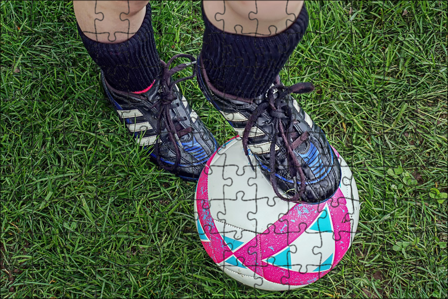 футбольные бутсы, мяч и ключ от дома на траве