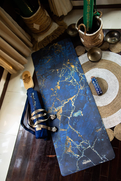 коврик для йоги и бутылка воды на деревянном полу