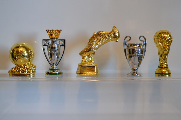 старые потертые футбольные мячи и кубок